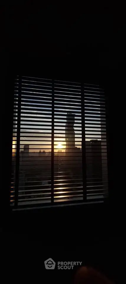 Stunning cityscape view through window blinds at sunset, perfect for urban living enthusiasts.