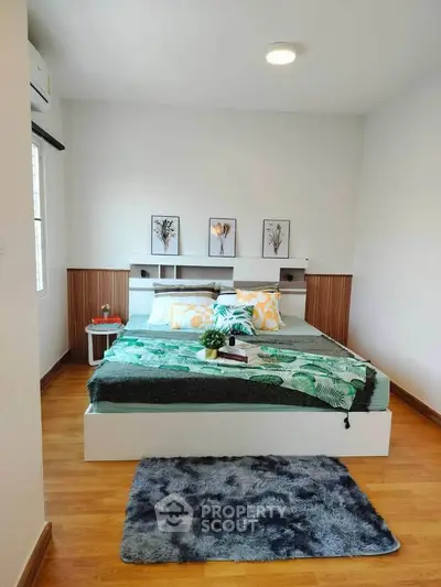 Modern bedroom with stylish decor and cozy ambiance, featuring wooden flooring and elegant furnishings.