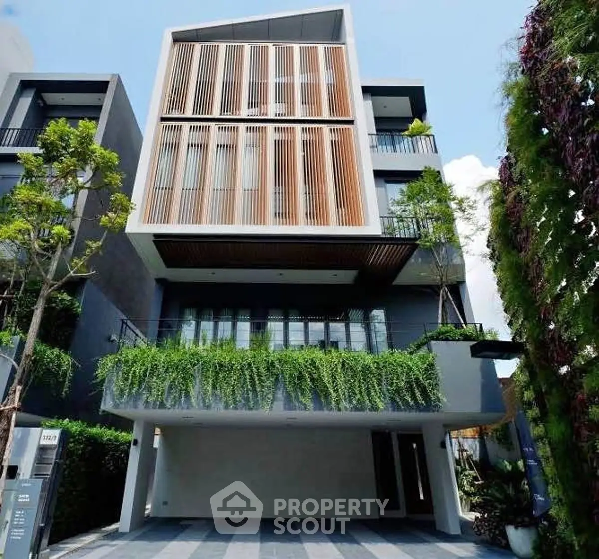 Modern multi-story building with lush greenery and sleek design