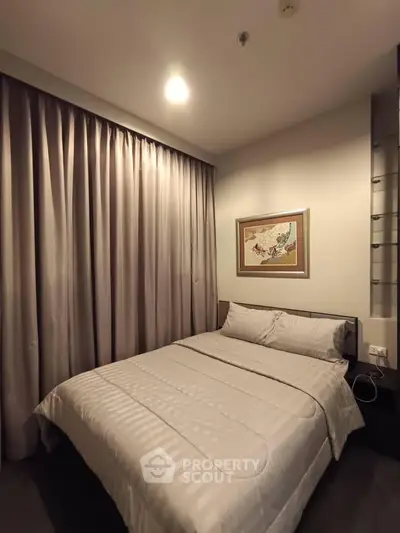Cozy bedroom with elegant curtains and framed artwork, perfect for restful nights.