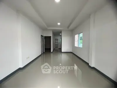 Spacious empty room with glossy tiled floors and bright natural light, ideal for customization.
