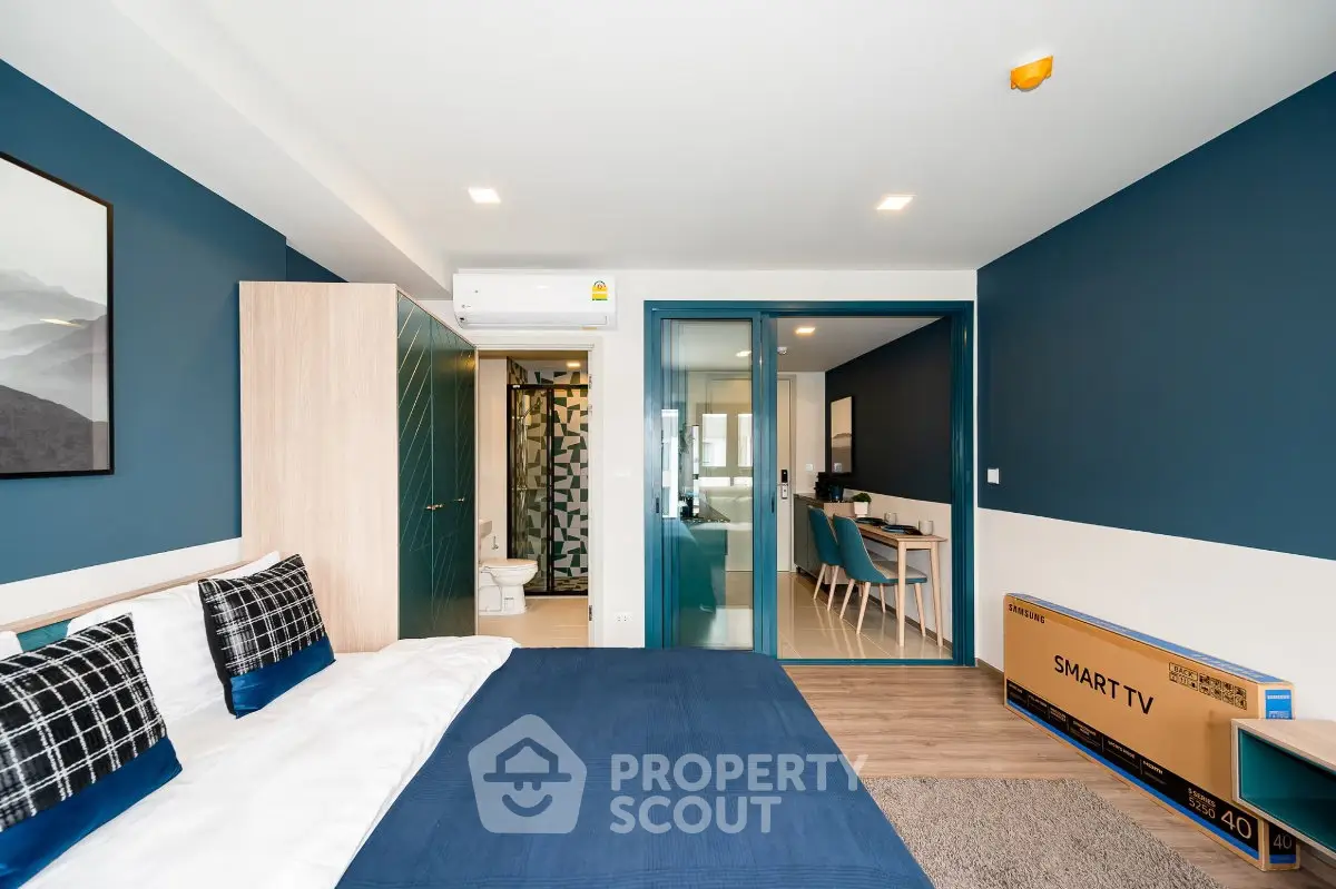 Modern bedroom with blue accents and smart TV in stylish apartment