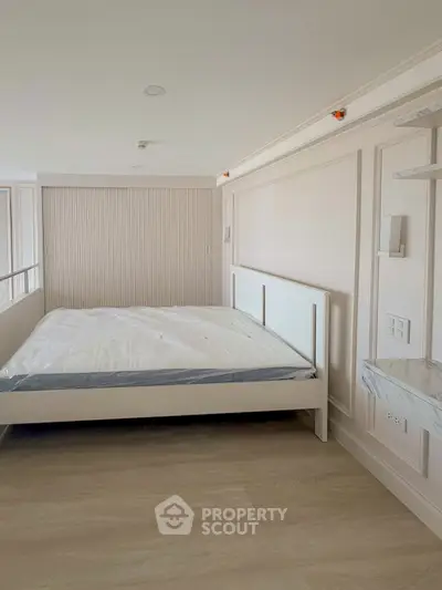 Spacious bedroom with modern design and natural light, featuring a large bed and elegant wall paneling.