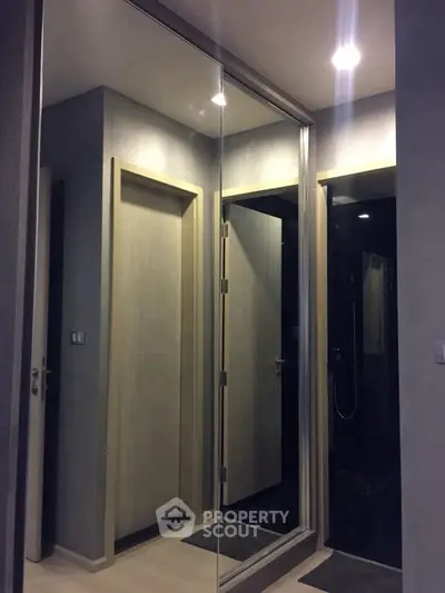 Modern bathroom with sleek design and mirrored closet doors.
