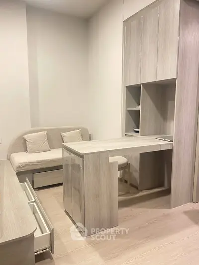 Modern compact living space with stylish wooden furniture and cozy seating area.