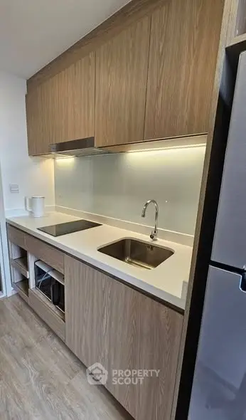 Modern kitchen with sleek wooden cabinetry and stainless steel appliances