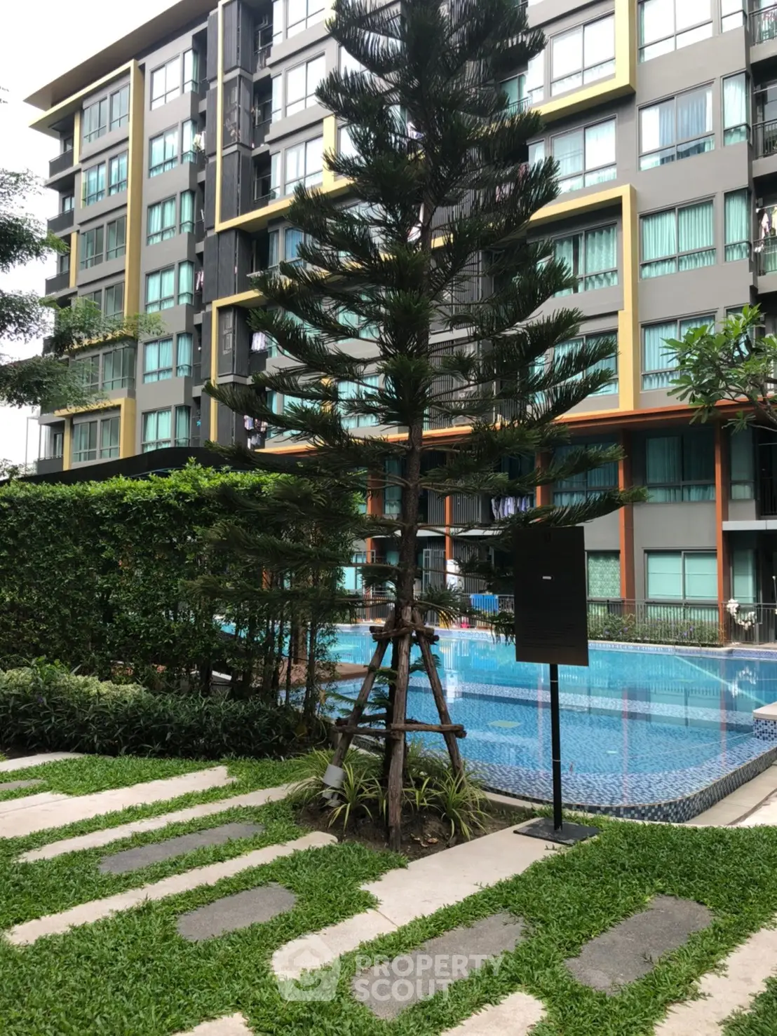 Modern condominium with lush garden and inviting swimming pool