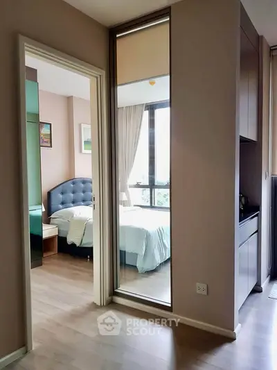 Modern bedroom with large window and stylish decor in a contemporary apartment.