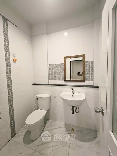 Modern bathroom with white tiles and sleek fixtures