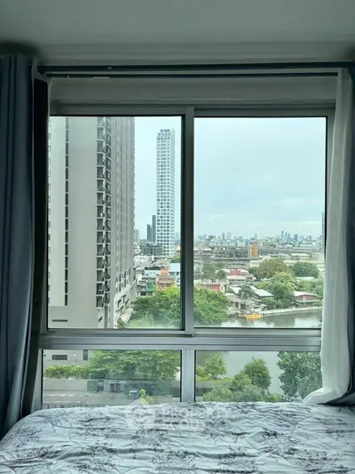 Stunning cityscape view from a modern bedroom window in a high-rise apartment.