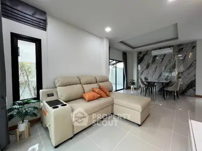 Modern living room with elegant marble accent wall and cozy beige sectional sofa.
