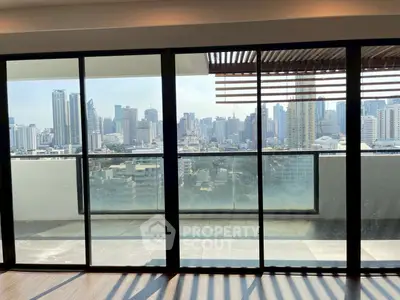 Stunning cityscape view from a modern high-rise balcony with glass doors.