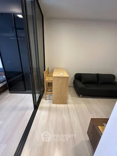 Modern living room with sleek glass partition and minimalist furniture