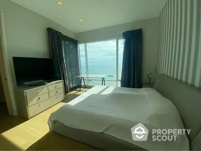 Spacious bedroom with stunning ocean view and modern furnishings.