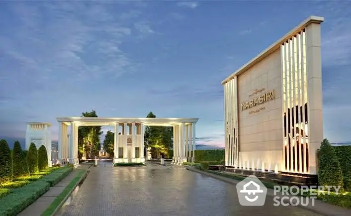 Luxurious entrance of upscale residential community with elegant architectural design and lush landscaping.