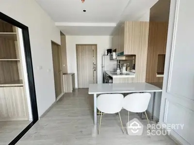 Modern kitchen with sleek design, featuring a compact dining area and stylish cabinetry, perfect for urban living.