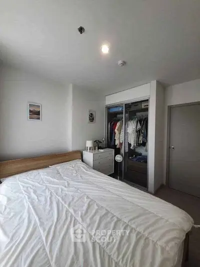 Cozy bedroom with modern closet and natural light, perfect for relaxation.