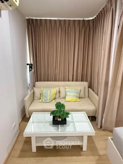 Cozy living room with beige sofa, stylish cushions, and elegant curtains, perfect for relaxation.