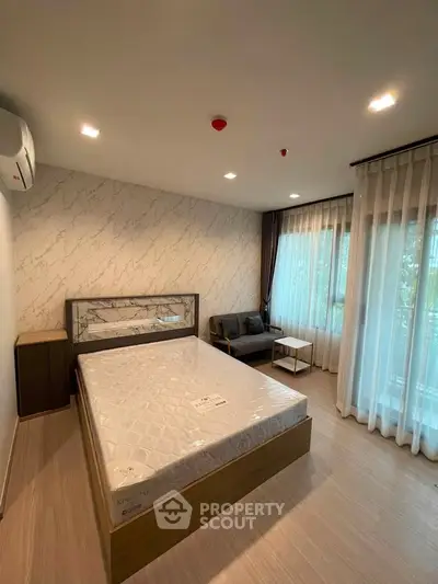 Modern bedroom with large windows and stylish decor in a cozy apartment.