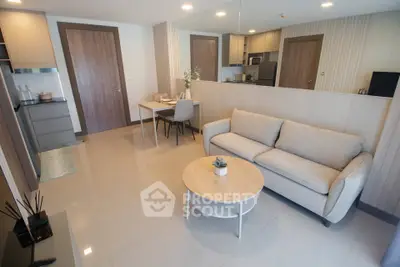 Modern living room with cozy sofa and dining area in open layout apartment.