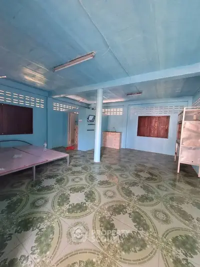 Spacious interior with unique patterned flooring and blue walls, ideal for creative customization.