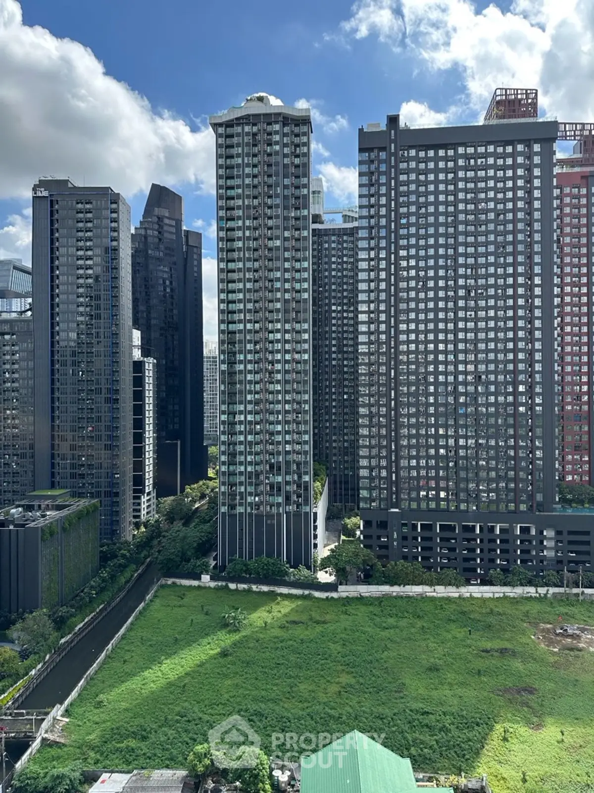 Stunning cityscape view of modern high-rise buildings with lush green foreground.