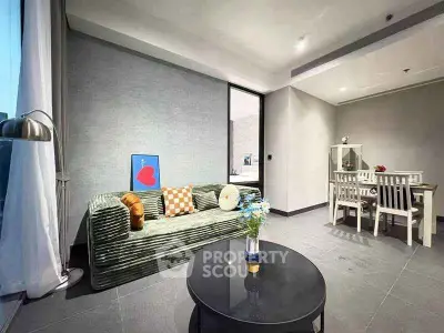 Modern living room with stylish decor and dining area, featuring cozy sofa and elegant table setting.