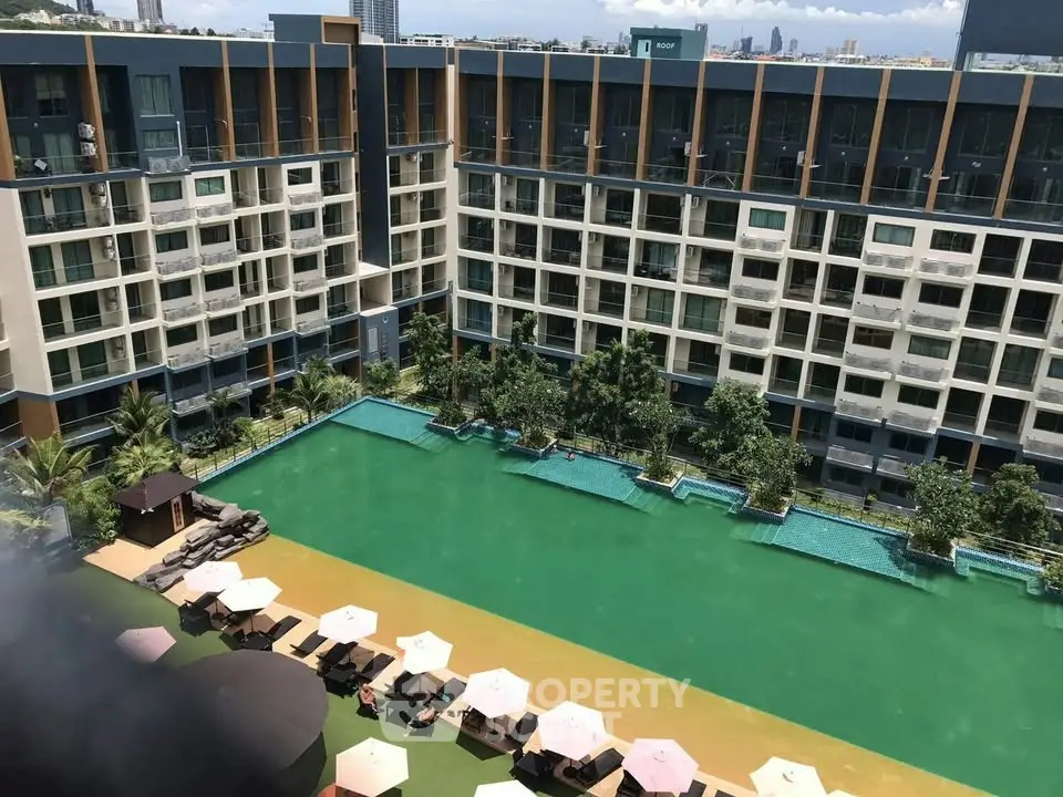 Luxurious apartment complex with stunning pool and lush greenery, perfect for modern living.