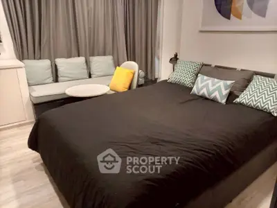 Cozy bedroom with modern decor and comfortable seating area, perfect for relaxation.