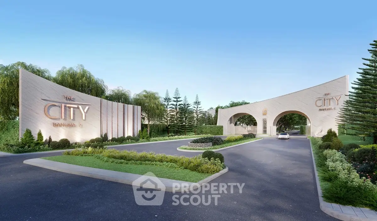 Elegant entrance of a modern residential complex with lush landscaping and clear blue sky.