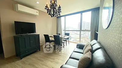 Stylish living room with chandelier, large window, and modern furniture in urban apartment.