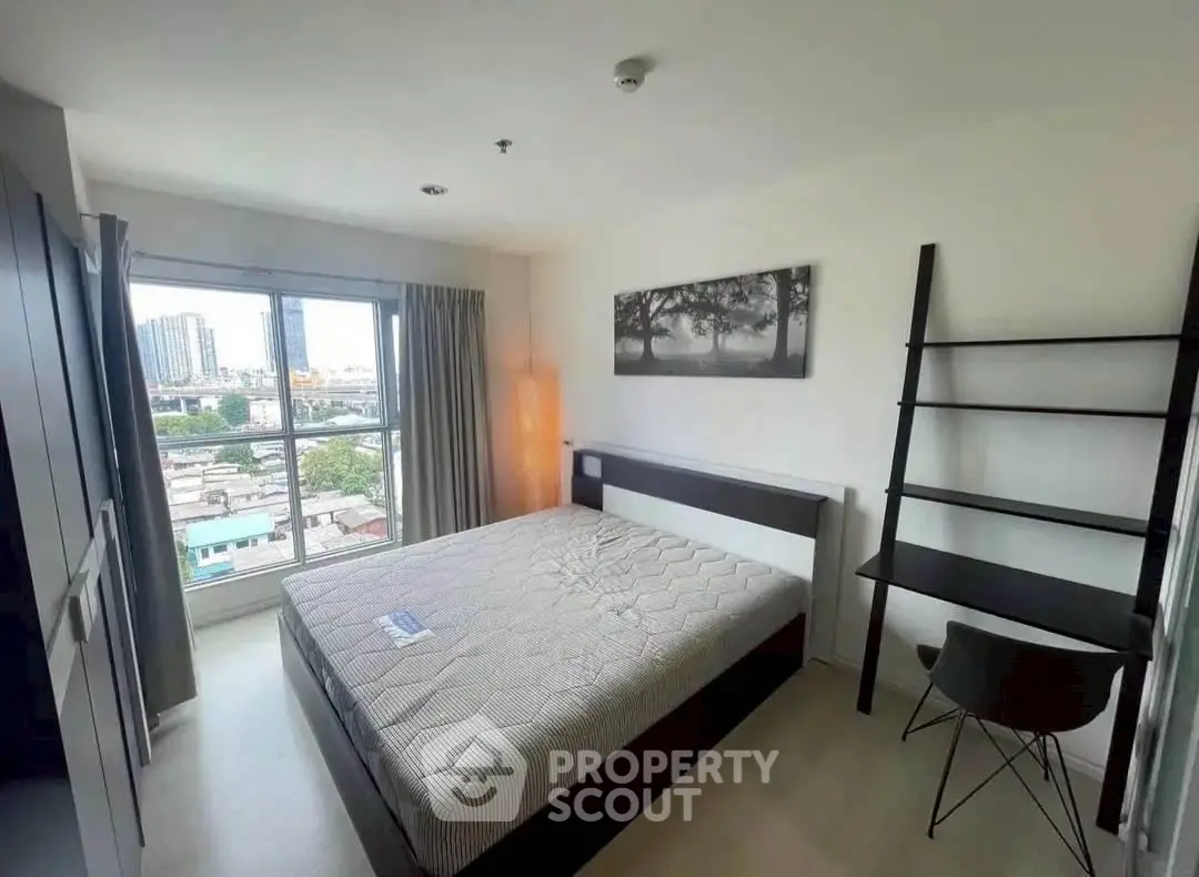 Modern bedroom with large window and city view, featuring a comfortable bed and sleek study desk.