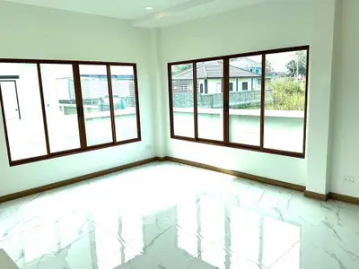 Bright and airy room with large windows and glossy tiled floor, perfect for modern living.