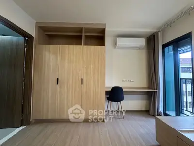 Modern bedroom with built-in wardrobe and study desk, featuring a balcony view.