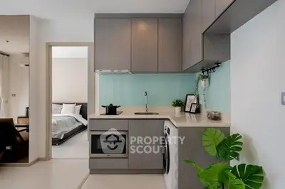 Modern compact kitchen with sleek cabinetry and integrated appliances in a stylish apartment.