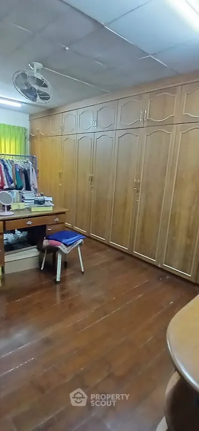 Spacious walk-in closet with wooden cabinetry and ample storage space