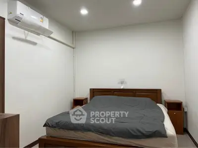 Cozy bedroom with modern air conditioning and wooden furniture