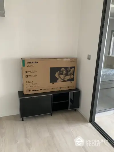 Modern apartment interior with new Toshiba TV box on sleek cabinet, showcasing minimalist design.