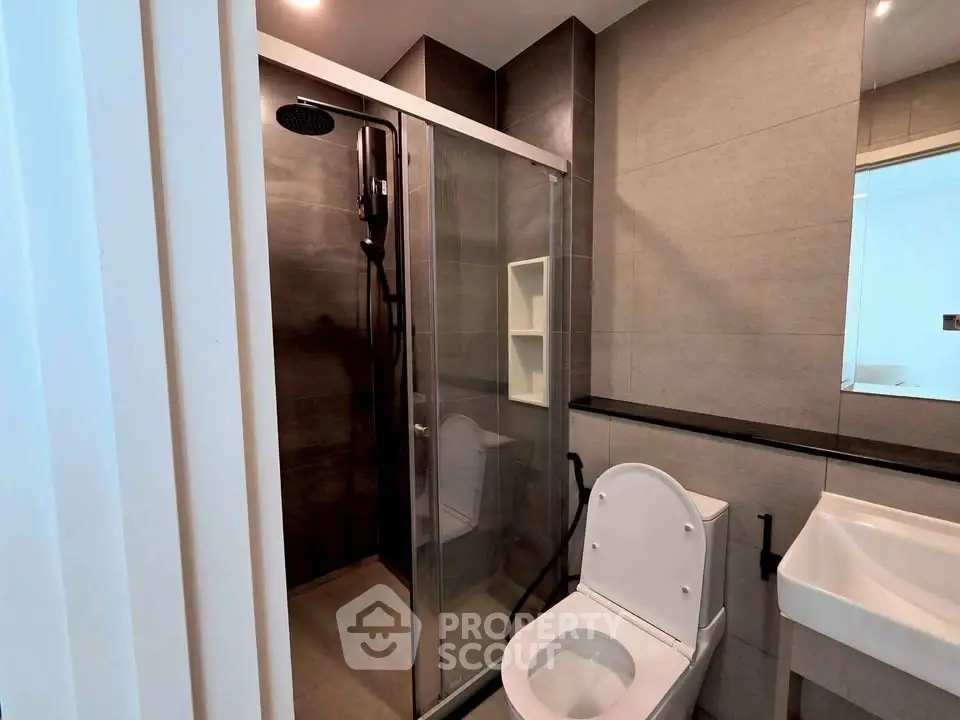 Modern bathroom with sleek shower and contemporary fixtures in a stylish apartment.