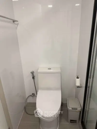 Modern bathroom with sleek white tiles and contemporary toilet design.