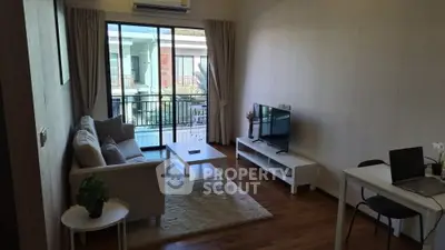 Modern living room with balcony view, featuring cozy sofa, TV, and wooden flooring.