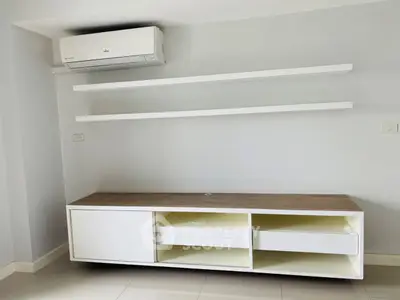 Modern minimalist living room with sleek white shelves and air conditioning unit.