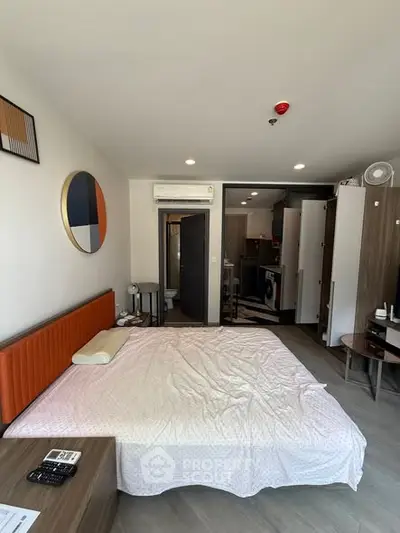 Modern bedroom with stylish decor and open layout, featuring a cozy bed and contemporary furnishings.