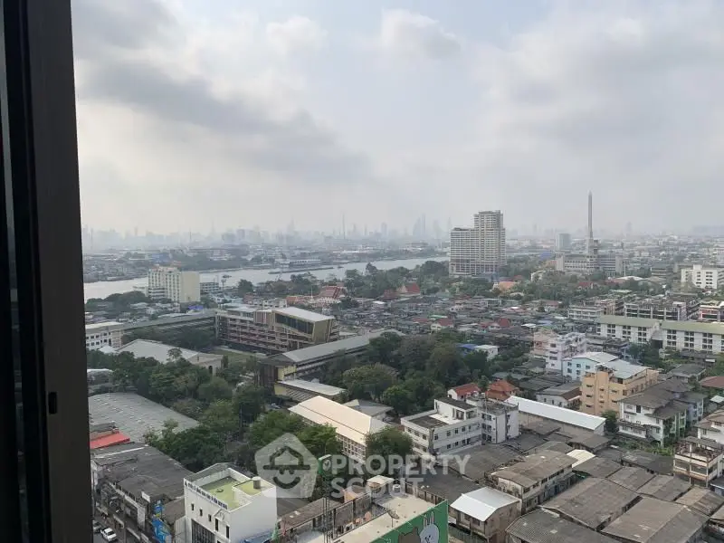 Stunning cityscape view from high-rise window showcasing urban skyline and river.