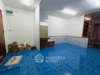 Spacious room with vibrant blue flooring and ample storage space, ideal for versatile living arrangements.
