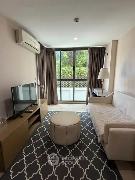 Cozy living room with modern decor, featuring a large window and stylish furniture.