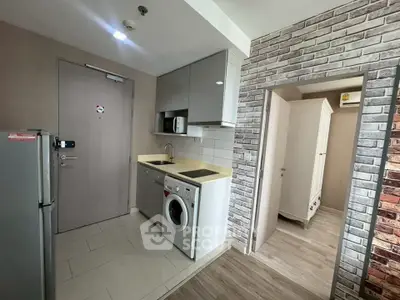 Modern compact kitchen with washing machine and sleek cabinetry in urban apartment.