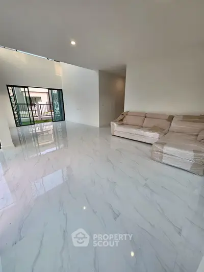 Spacious living room with modern marble flooring and large windows for natural light.