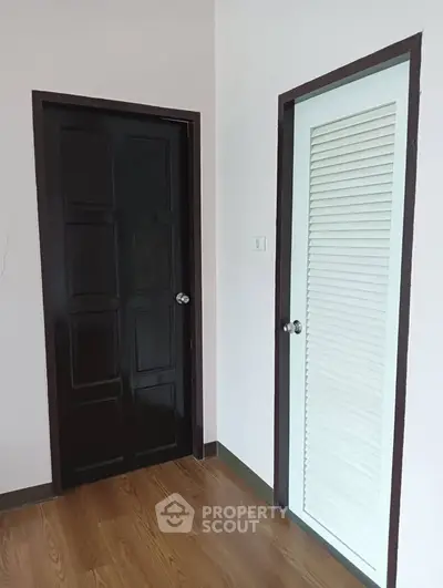 Minimalist interior with wooden and louvered doors on polished floor