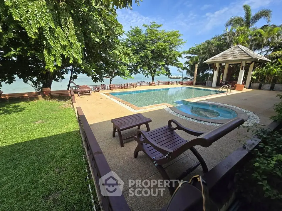 Luxurious outdoor pool area with lush greenery and ocean view, perfect for relaxation and leisure.